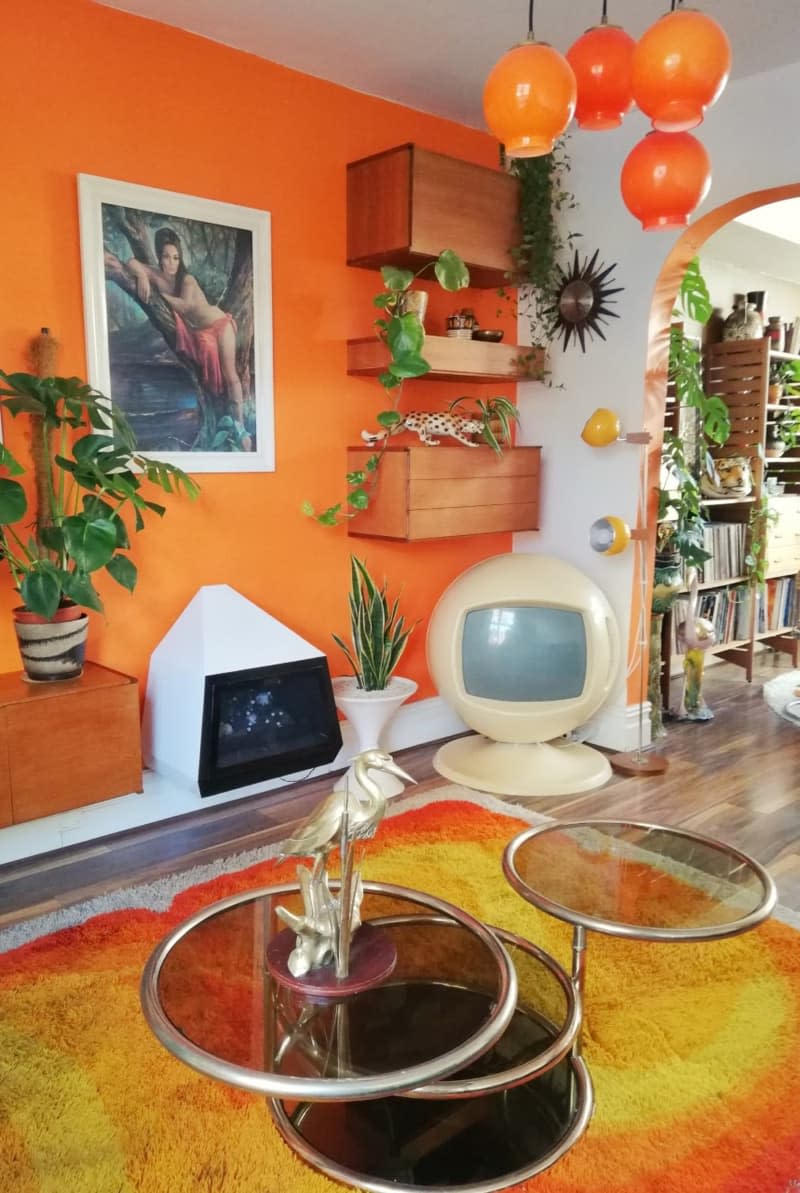 An orange living room with retro 70's items.