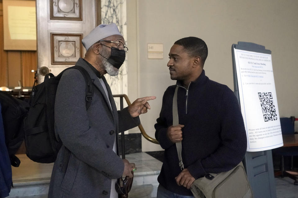 Task Force vice-chair Dr. Amos Brown, left, speaks with outgoing Richmond, Calif., city council member Demnlus Johnson III during a break from meetings by the Task Force to Study and Develop Reparation Proposals for African Americans, Wednesday, Dec. 14, 2022, in Oakland, Calif. (AP Photo/Jeff Chiu)