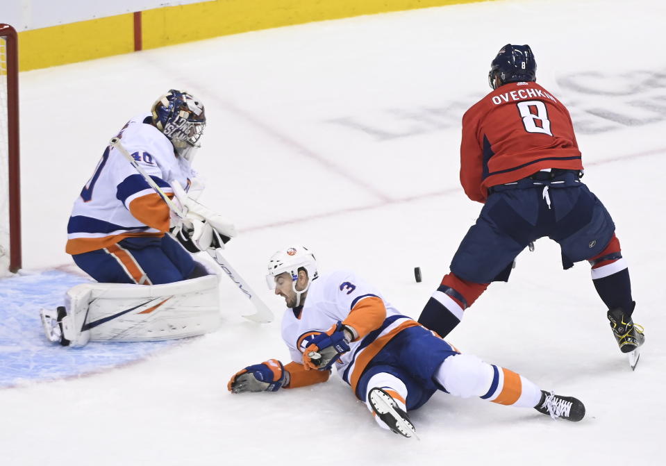 New York Islanders goaltender Semyon Varlamov (40) stops Washington Capitals left wing Alex Ovechkin (8) as Capitals defenseman Nick Jensen (3) falls to the ice during the first period of an NHL Eastern Conference Stanley Cup hockey playoff game in Toronto, Wednesday, Aug. 12, 2020. (Nathan Denette/The Canadian Press via AP)