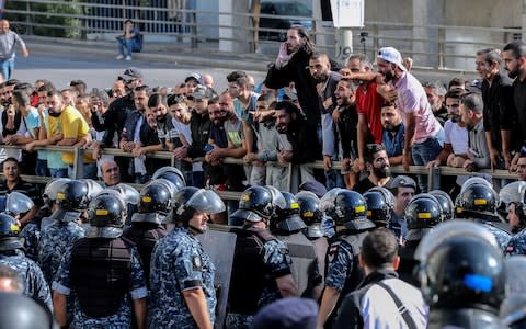 Lebanese riot policemen face off with anti-protest demonstrators shouting pro-Hizbollah and Amal Movement slogans in Beirut - Credit: REX