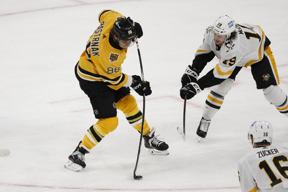 Boston Bruins' David Pastrnak lets go with a shot past Pittsburgh Penguins' Jared McCann during the first period of an NHL hockey game Saturday, April 3, 2021, in Boston. (AP Photo/Winslow Townson)