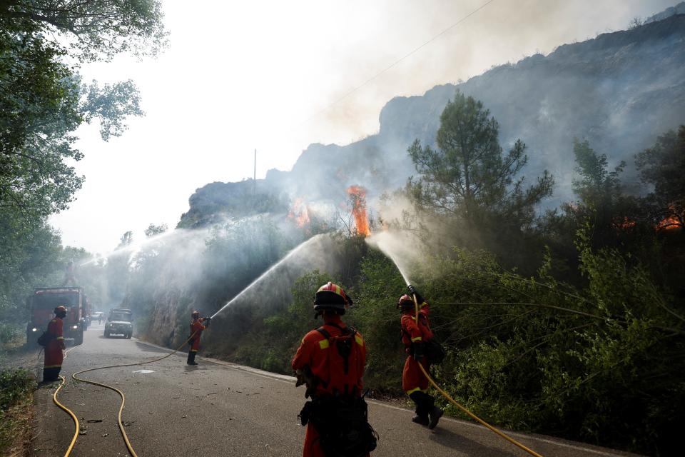 Members of the Military Emergencies Unit work to extinguish a wildfire near Artesa de Segre, Catalonia (Reuters)