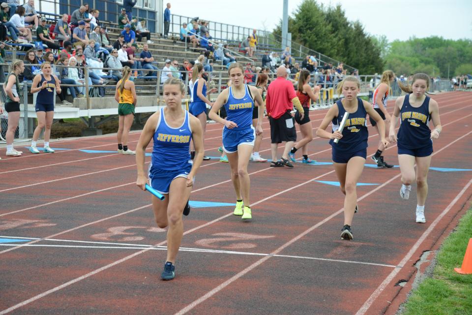 Kim Miller of Jefferson hands off to teammate Alyssa Masserant and Erie Mason's Audrey Trainor gives the baton to Elizabeth Lambert during the 1,600 relay at the 58th annual Mason Invitational Saturday.