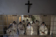 Las monjas del convento de Santa Catalina de Santorini hablan con periodistas del otro lado de unas rejas que marcan la zona de clausura el 14 de junio del 2022. (AP Photo/Petros Giannakouris)