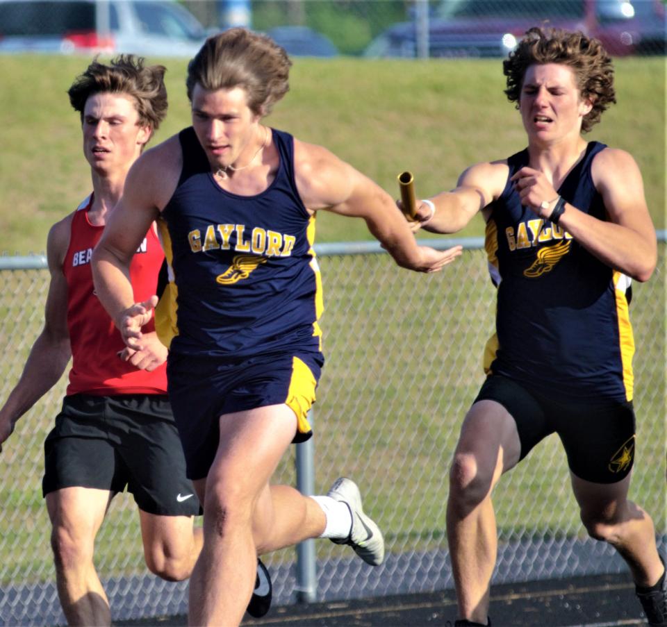 Gage Looker (left) takes the baton from Caleb Aungst (right) in the 4x100-meter relay during the Northern Michigan Meet of Champions on Tuesday, May 30 in Gaylord, Mich.