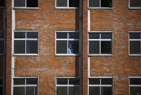 A medical personnel looks out from the window of the army hospital where the rescued victims of avalanches have been admitted to in Kathmandu October 16, 2014. REUTERS/Navesh Chitrakar