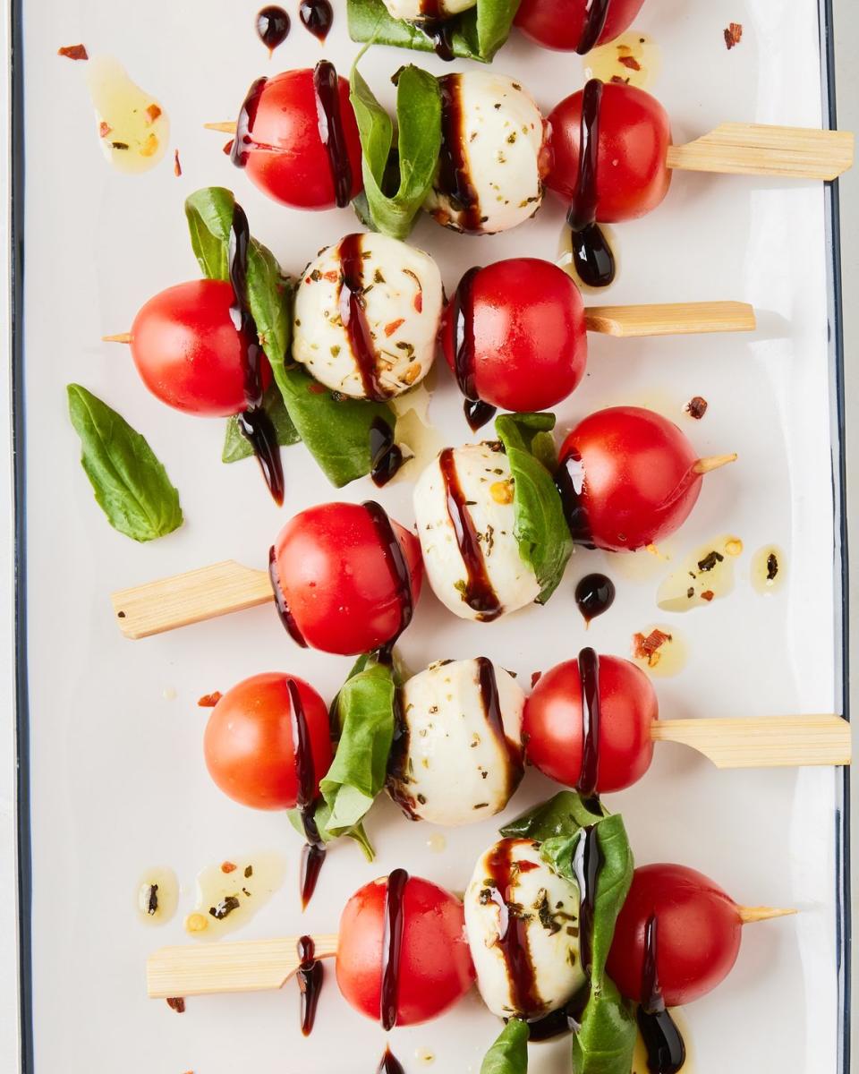 tomato, mozzarella, and basil on little skewers drizzled with balsamic glaze