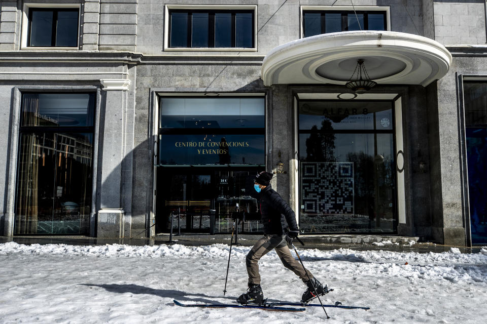 A man skis at Espana square in downtown Madrid, Spain, Sunday, Jan. 10, 2021. A large part of central Spain including the capital of Madrid are slowly clearing snow after the country's worst snowstorm in recent memory. (AP Photo/Manu Fernandez)