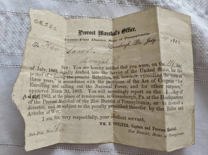 A worn letter from the Provost Marshal's Office dated July 14, 1863, notifying an individual of their draft into U.S. military service during the Civil War