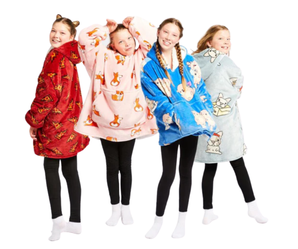 Four girls stand on a white background in black leggings and white socks wearing different coloured Oodies.