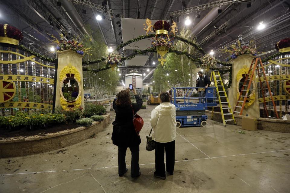 This Thursday, Feb. 28, 2013 photo shows a woman taking a photograph during preparations for the annual Philadelphia Flower Show at the Pennsylvania Convention Center in Philadelphia. More than 270,000 people are expected to converge on the Pennsylvania Convention Center for the event, which runs through March 10. Billed as the world's largest indoor flower show, it's also one of the oldest, dating back to 1829. (AP Photo/Matt Rourke)