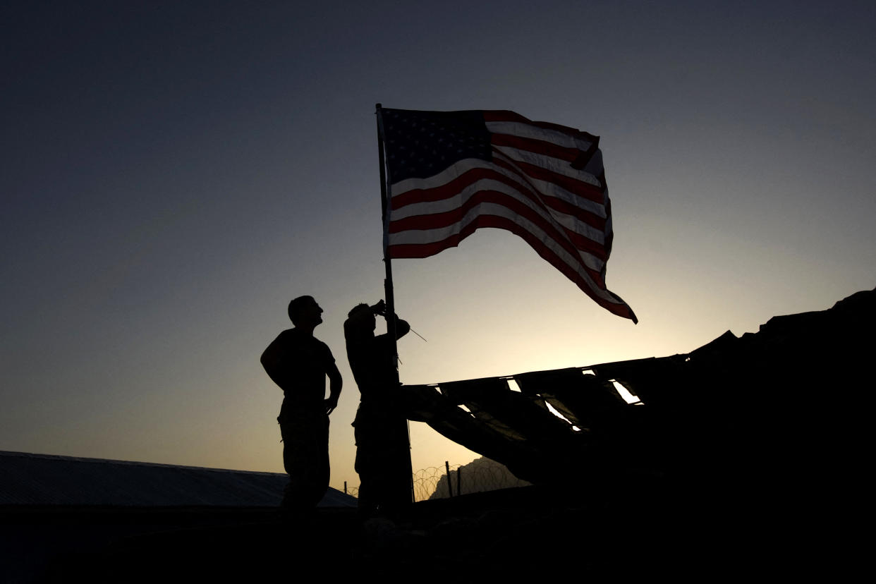 U.S. Marines raise a flag over their base in the Farah Province of southern Afghanistan on Oct. 6, 2009. (David Furst / AFP via Getty Images)