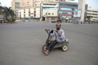 A physically challenged man rides a tri-cycle through a deserted road junction during a one-day Janata (civil) curfew imposed amid concerns over the spread of the COVID-19 novel coronavirus, in Secunderabad, the twin city of Hyderabad, on March 22, 2020. (Photo by NOAH SEELAM / AFP) (Photo by NOAH SEELAM/AFP via Getty Images)