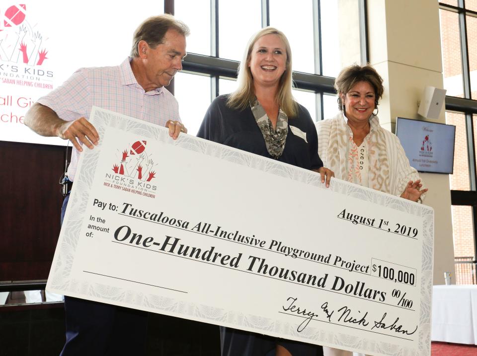 Nick Saban and his wife Terry present a $100,000 check to Caroline Lasseter for the Tuscaloosa All-Inclusive Playground Project during the annual Nick's Kids Foundation luncheon in Bryant-Denny Stadium on Aug. 1, 2019.