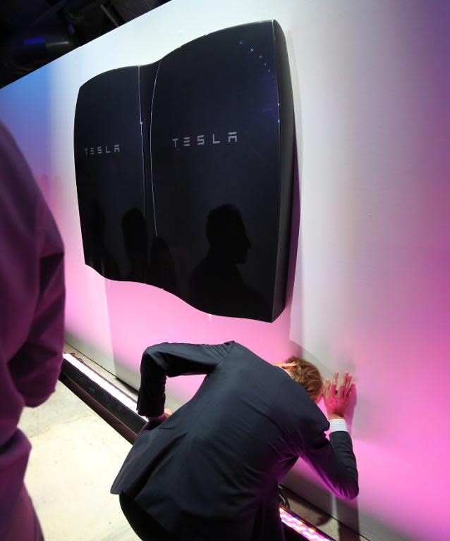 People look at newly-unveiled Tesla Powerwall batteries at the Tesla Design Studio in Hawthorne, California, April 30, 2015