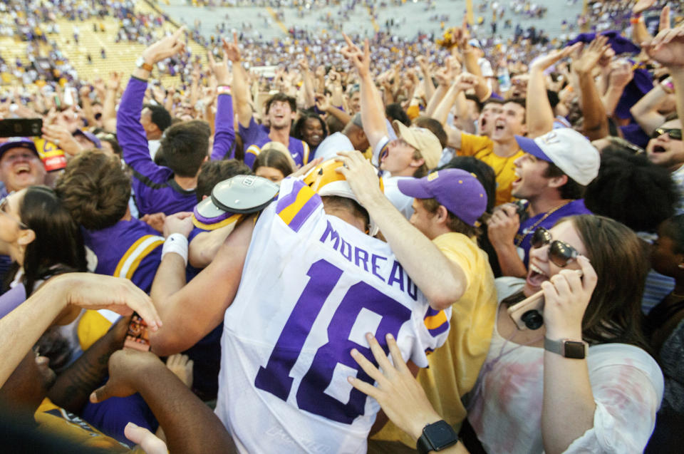 LSU's Foster Moreau (18) is surrounded as fans rush the field after the Tigers 36-16 win over Georgia in an NCAA college football in Baton Rouge, La., Saturday, Oct. 13, 2018. (AP Photo/Matthew Hinton)