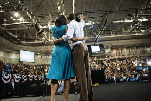US President Barack Obama and First Lady Michelle Obama wave to supporters after a campaign event in Richmond, Virginia