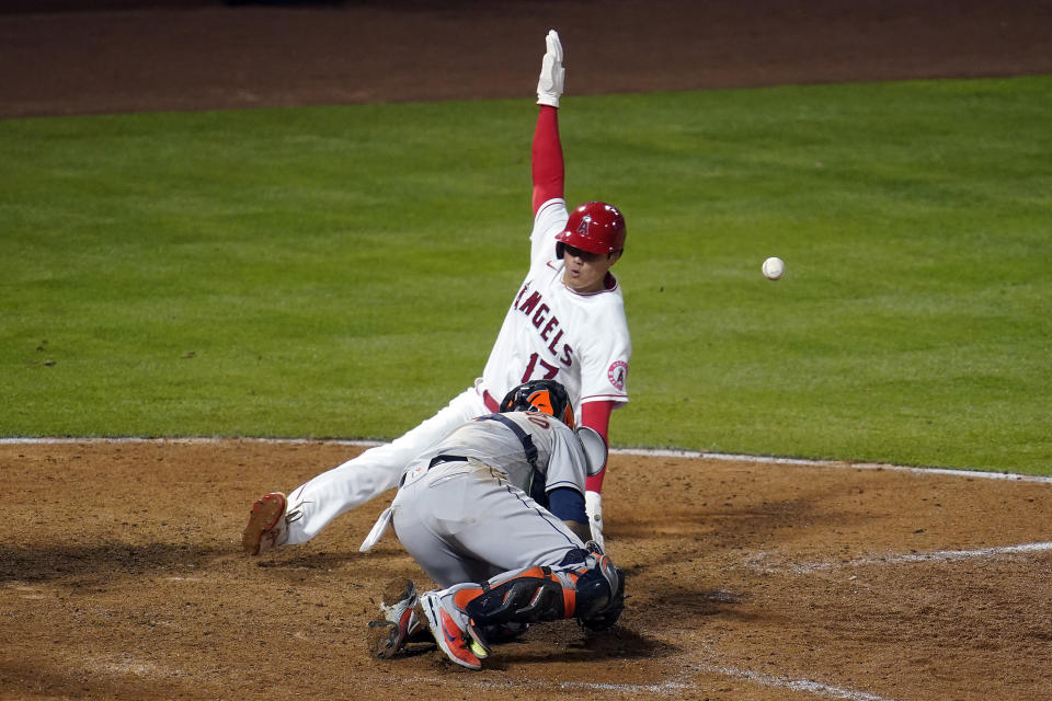 Los Angeles Angels' Shohei Ohtani (17) scores on a fielder's choice past Houston Astros catcher Martin Maldonado on a ground ball by Jared Walsh during the eighth inning of a baseball game, Monday, April 5, 2021, in Anaheim, Calif. (AP Photo/Marcio Jose Sanchez)