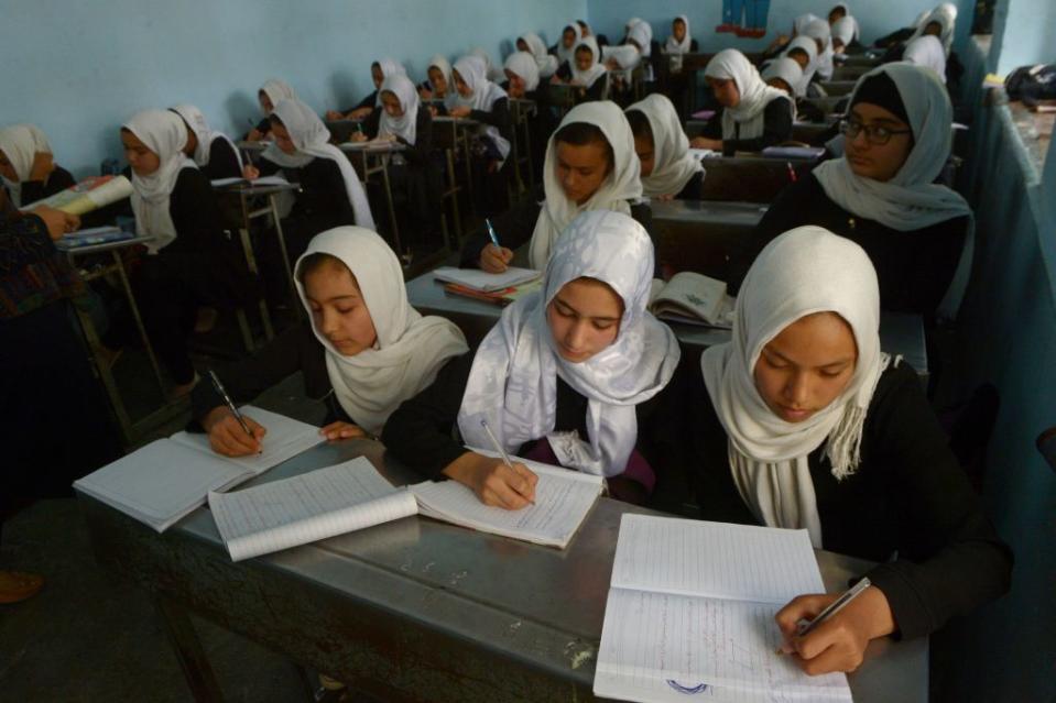 Afghan girls study during a lesson at a school in Herat province on October 17, 2017.