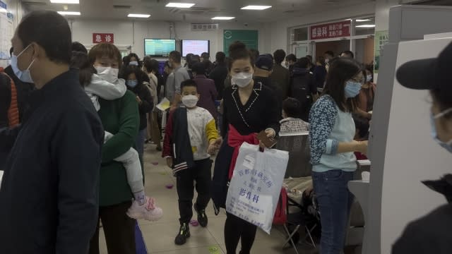 Parents with their children wait at a crowded holding room of a children's hospital in Beijing.