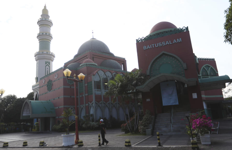 A man walks near an empty mosque in Jakarta, Indonesia, Tuesday, July, 20, 2021. Muslims across Indonesia marked a grim Eid al-Adha festival for a second year Tuesday as the country struggles to cope with a devastating new wave of coronavirus cases and the government has banned large gatherings and toughened travel restrictions. (AP Photo/Achmad Ibrahim)