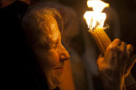 Christian pilgrim holds candles at the church of the Holy Sepulcher, traditionally believed to be the burial site of Jesus Christ, during the ceremony of the Holy Fire in Jerusalem's Old City, Saturday, April 19, 2014. The "holy fire" was passed among worshippers outside the Church and then taken to the Church of the Nativity in the West Bank town of Bethlehem, where tradition holds Jesus was born, and from there to other Christian communities in Israel and the West Bank. (AP Photo/Dan Balilty)