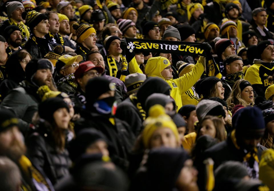 A Columbus Crew supporter holds a "Save the Crew" scarf during the second half of an MLS Eastern Conference final game against the Toronto FC in 2017. Fans had a hard time getting in that November night because only one entry gate was open.