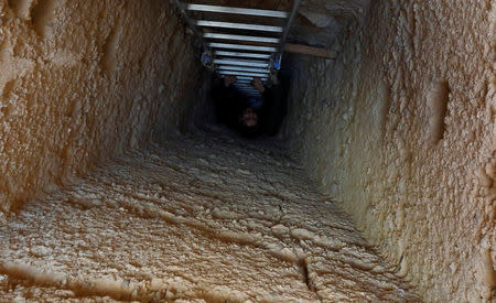 A journalist is seen on the ladder at the entrance to the tombs, during the presentation of a new discovery at Tuna el-Gebel archaeological site in Minya Governorate, Egypt, February 2, 2019. REUTERS/Amr Abdallah Dalsh