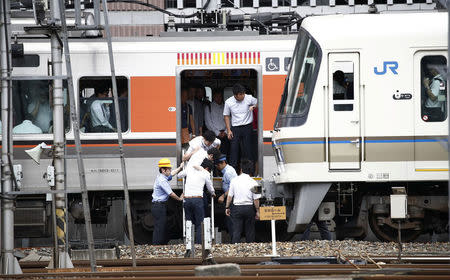 Passengers get off a train which its operation is suspended in Osaka, Osaka prefecture, western Japan, in this photo taken by Kyodo June 18, 2018. Mandatory credit Kyodo/via REUTERS