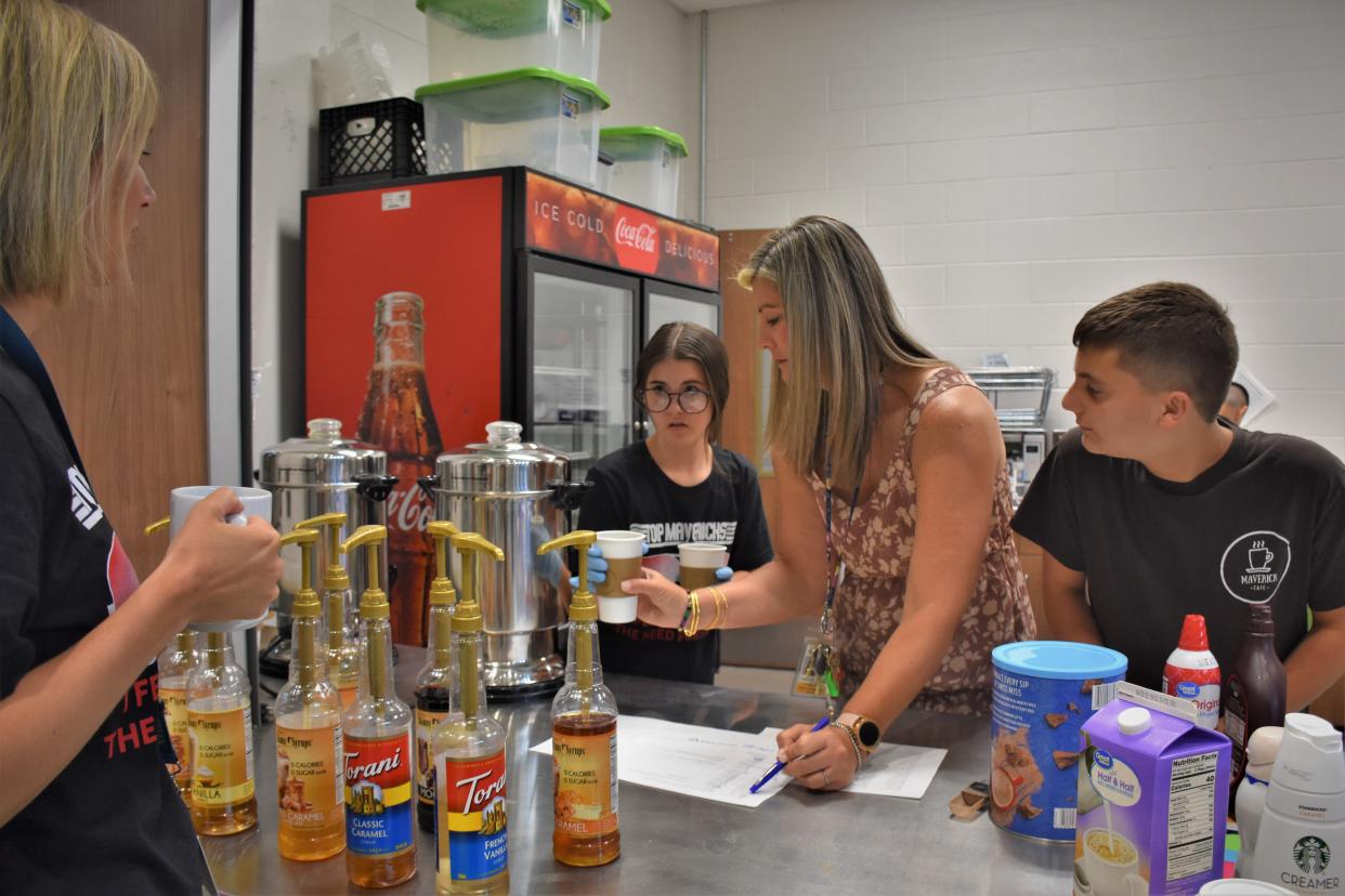 Student support teacher Katie Shyamsunder assists students as they serve early morning coffee and pastries to teachers at Mill Creek Middle School in Nolensville, Tennessee on Friday, May 20, 2022.