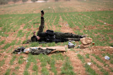 A rebel fighter rests on the ground east of al-Bab town, Syria March 9, 2017. REUTERS/Khalil Ashawi