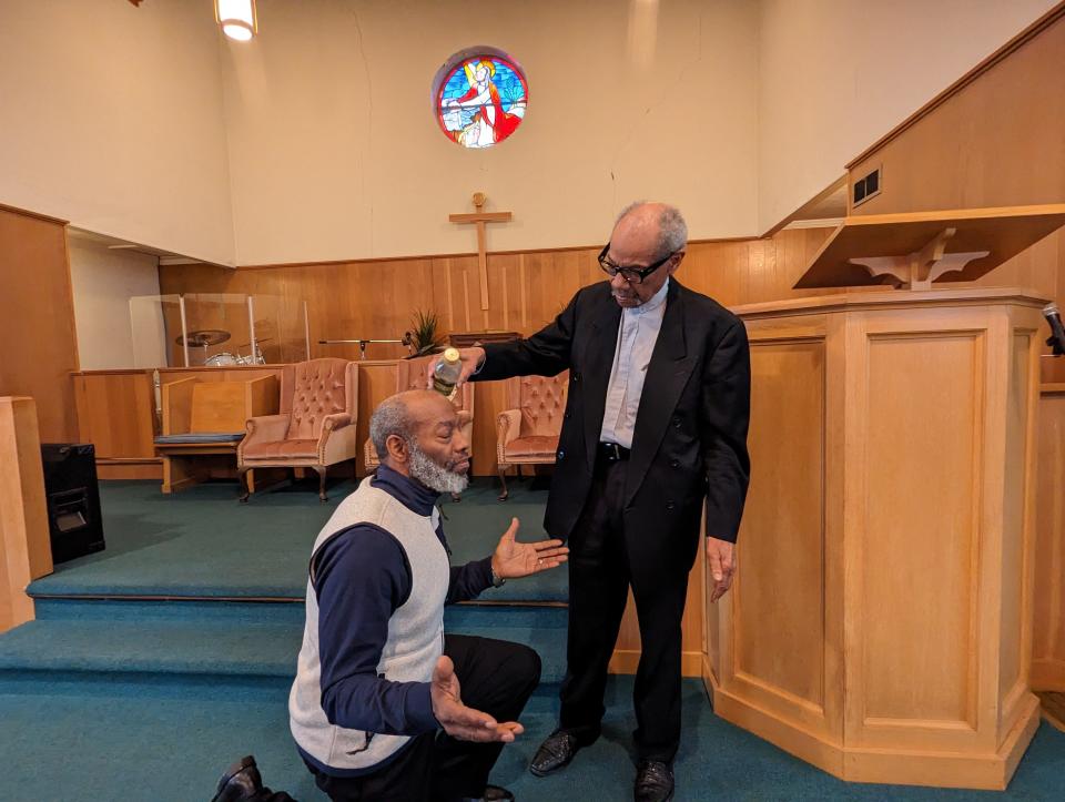 The Rev. Willie Wilder demonstrates how he plans to anoint his son, Curtis as the new pastor of True Vine Revival Center on March 17. Willie Wilder started the Canton church in the 1990s.