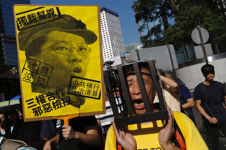 A demonstrator holds cardboard jail bars, as he protests of the jailing of student leaders Joshua Wong, Nathan Law and Alex Chow, who were imprisoned for their participation of the 2014 pro-democracy Umbrella Movement, also known as "Occupy Central" protests, in Hong Kong China August 20, 2017. REUTERS/Tyrone Siu