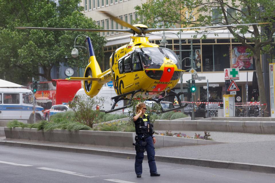 A police officer walks as a first-response helicopter takes off at the scene where a car crashed into a group of people near Breitscheidplatz in Berlin (REUTERS)