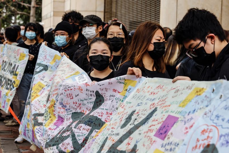 Supporters of pro-democracy activists hold a banner as they queue up for a court hearing over national security law outside West Kowloon Magistrates' Courts, in Hong Kong