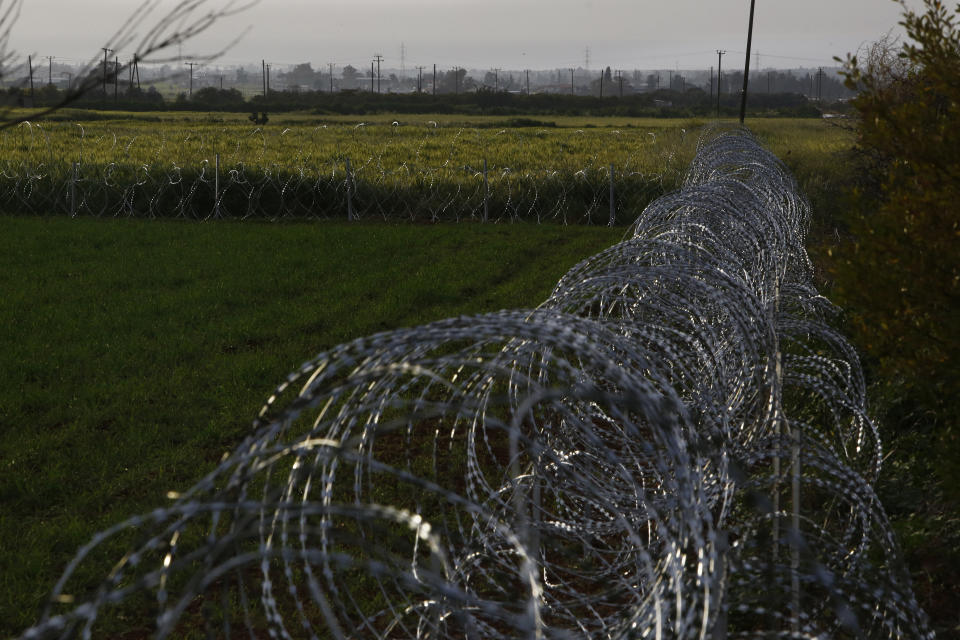 Razor wire is seen along the southern side of a U.N buffer zone that cuts across the ethnically divided Cyprus, near village of Astromeritis, Tuesday, March 9, 2021. The government of ethnically split Cyprus has come under fire over a decision to lay razor wire along a section of a U.N. controlled buffer zone it said is needed to stem migrant inflows from the island's breakaway north, with critics charging that the "ineffective" scheme only feeds partitionist perceptions amid a renewed push resume dormant peace talks. (AP Photo/Petros Karadjias)