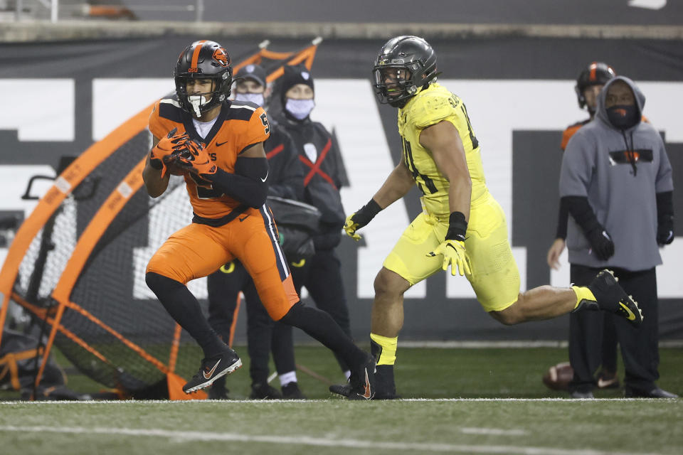 Nov 27, 2020; Corvallis, Oregon, USA; Oregon State Beavers wide receiver Kolby Taylor (5) catches a pass against Oregon Ducks linebacker Isaac Slade-Matautia (right) during the second half at Reser Stadium. Mandatory Credit: Soobum Im-USA TODAY Sports