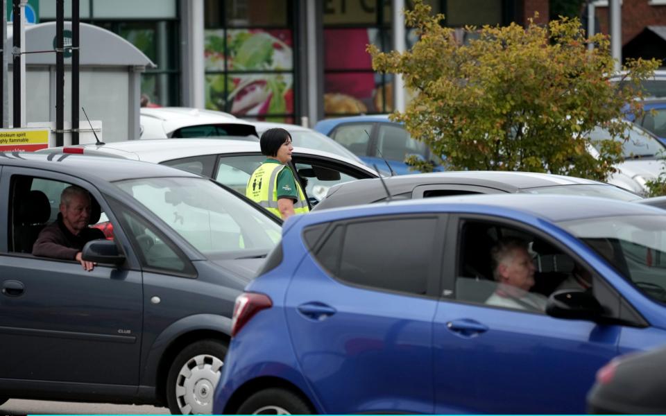A store worker directs traffic as people queue for petrol at a Morrisons in Ellesmere Port, Cheshire  - Christopher Furlong /Getty Images Europe 