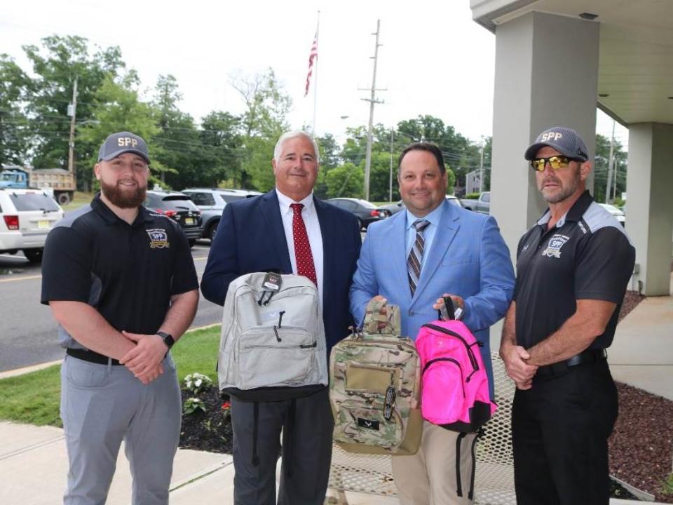 Kelly Conklin Jr. (l), Toms River Regional Assistant Superintendent Jim Ricotta, Superintendent Mike Citta and Kelly Conklin Sr. after the Conklins company donated 20 armored backpacks to Toms River schools.