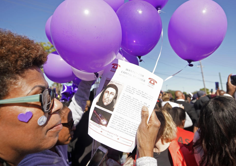 Donna Thomas holds a flyer about the shooting suspect as she attends a community rally for seven-year-old Jazmine Barnes on Saturday, Jan. 5, 2019 in Houston. Barnes was killed when a driver shot into the car she and her family were driving in last Sunday. (Melissa Phillip/Houston Chronicle via AP)