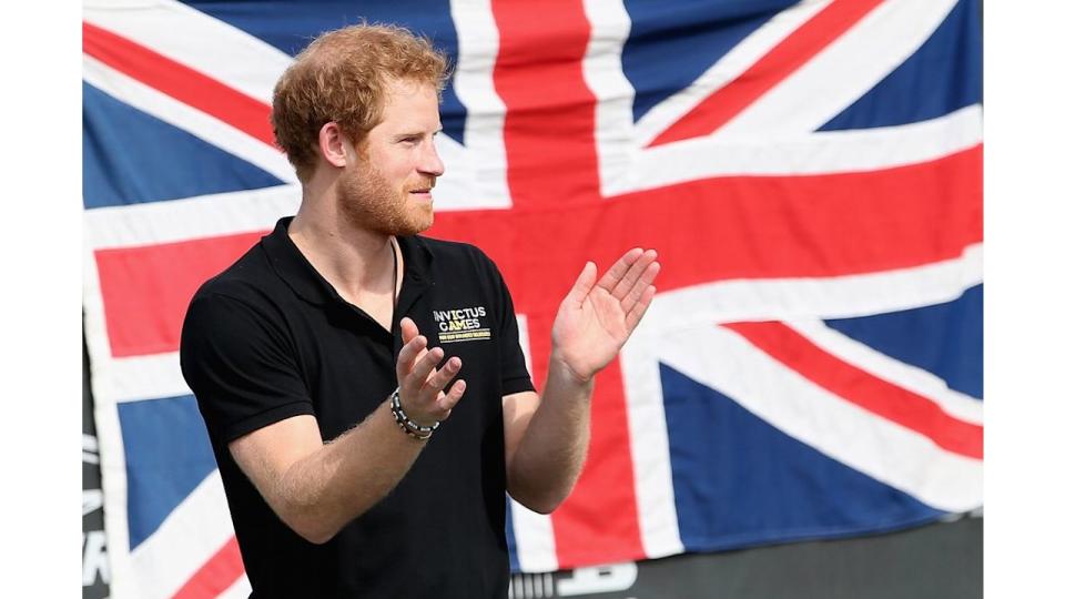 Prince Harry standing in front of a Union Jack