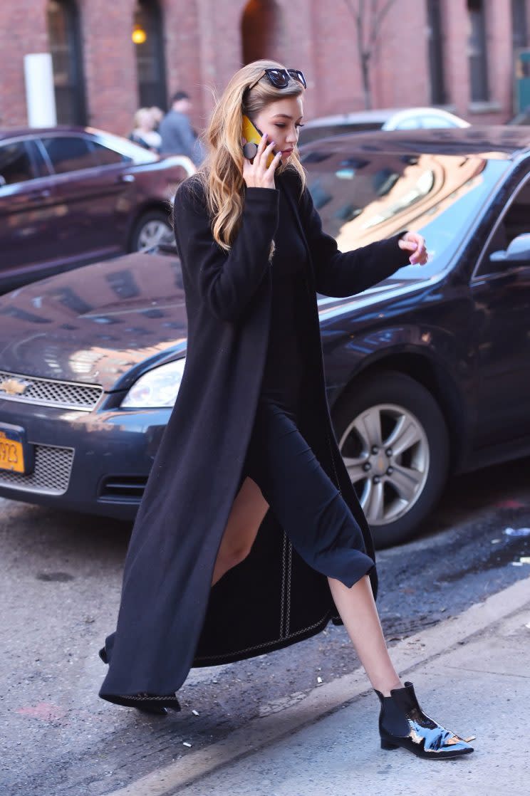 The model was spotted in March is another extremely long black coat. (Photo: Getty Images)