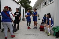 In this Wednesday, May 22, 2019 photo, members of Hestia FC Women's Refugee Soccer team talk outside the locker room before a train session in Athens. Many of the players at Hestia FC weren't allowed to play or even watch soccer matches in their home countries. Hestia FC was set up by the Olympic Truce Centre, a non-government organization created in 2000 by the International Olympic Committee and Greek Foreign Ministry. (AP Photo/Thanassis Stavrakis)