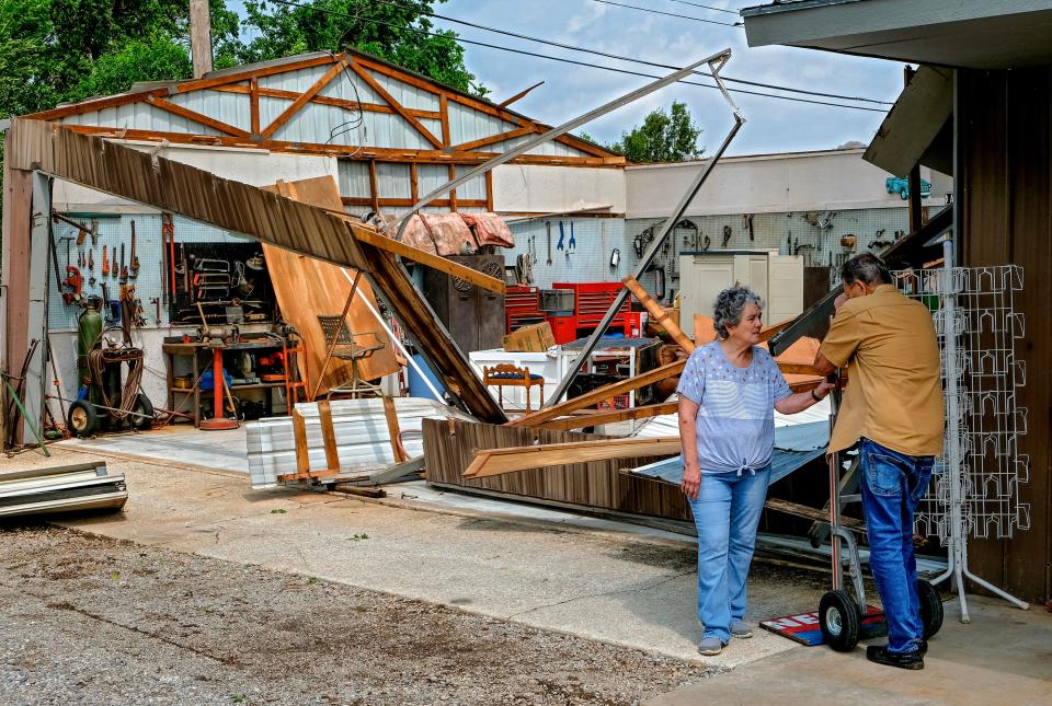 Noble residents Bill Edmondson, 79, and his wife, Linda, 72, married for 54 years, survey Friday the damage done to their garage/shop from tornado aftermath in Noble.