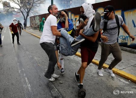 Un manifestante herido es ayudado por otros durante una protesta contra el gobierno en Caracas en Venezuela. 10 de abril de 2017. Un joven murió por un disparo en Venezuela durante una manifestación contra el gobierno de Nicolás Maduro la noche del lunes, informó la Fiscalía en un comunicado, elevando a dos el número de fallecidos tras una nueva ola de protestas callejeras en la nación sudamericana. REUTERS/Carlos Garcia Rawlins