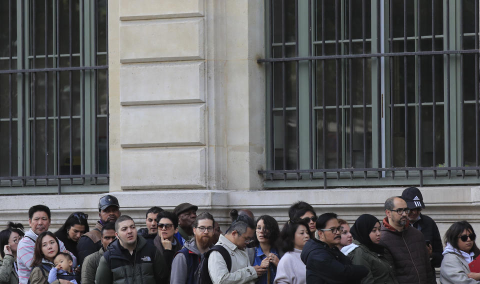 People line up outside the police headquarters in Paris, Friday, Oct. 4, 2019. The French government says there is nothing to suggest the police employee who stabbed four colleagues to death at Paris police headquarters yesterday was radicalized. (AP Photo/Michel Euler)