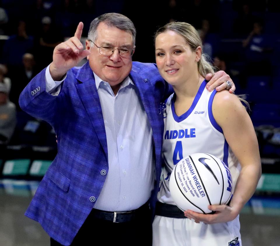 Middle Tennessee women's basketball coach Rick Insell poses with guard Savannah Wheeler (4) after she received a basketball celebrating being the Conference USA all-time career record free throw leader at 579.