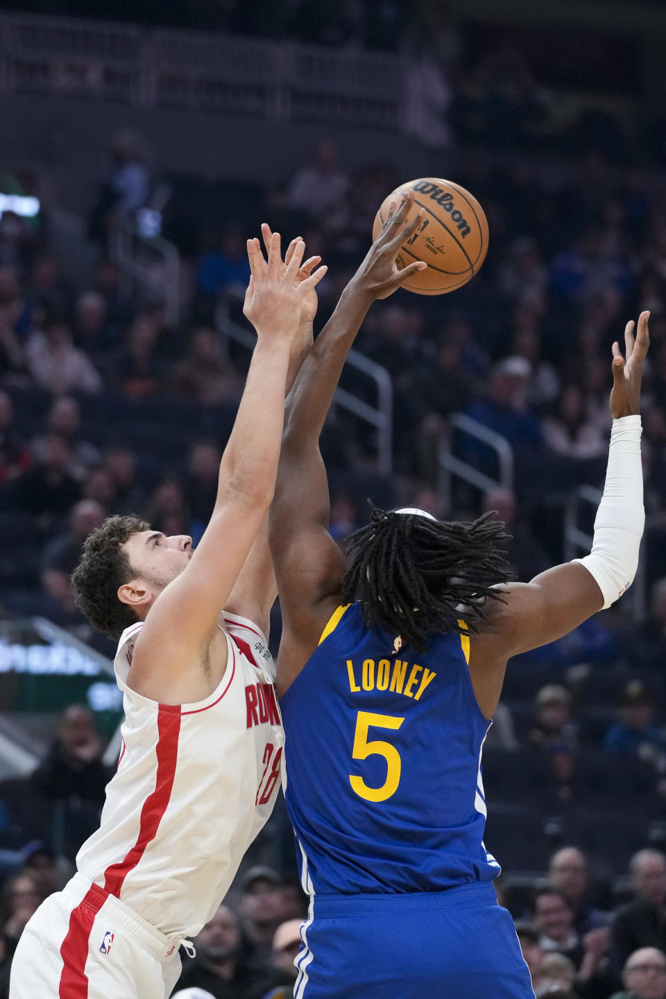 Houston Rockets center Alperen Sengun, left, and Golden State Warriors center Kevon Looney compete for possession of the ball during the first half of an NBA basketball game in San Francisco, Friday, Feb. 24, 2023. (AP Photo/Godofredo A. Vásquez)