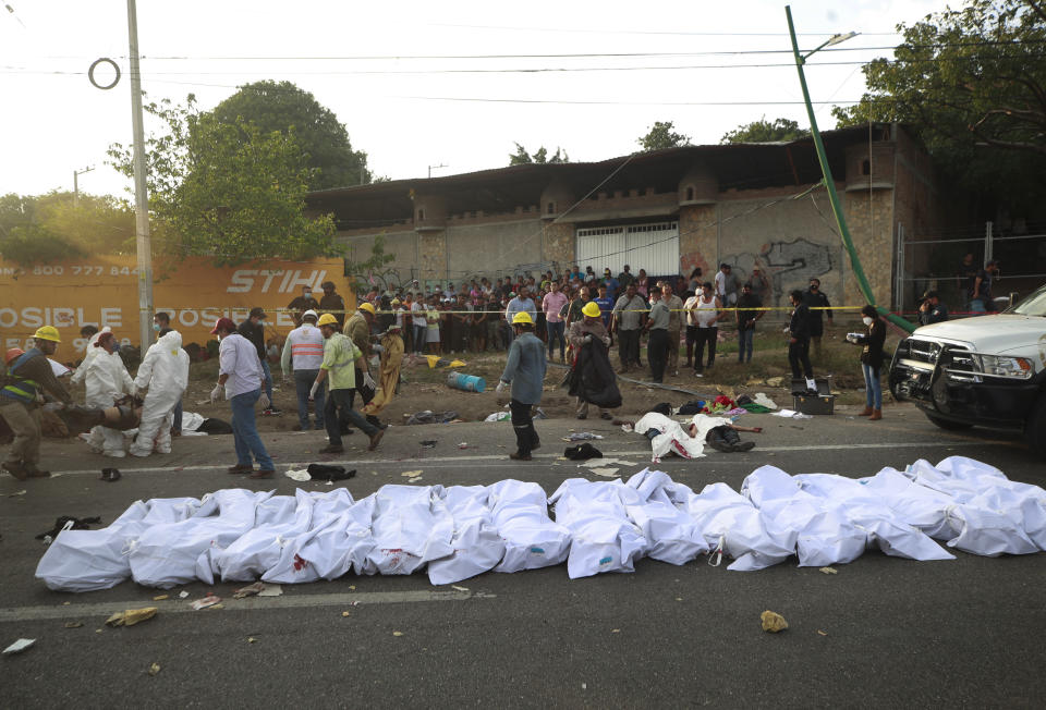 Bodies in bodybags are placed on the side of the road after an accident in Tuxtla Gutierrez, Chiapas state, Mexico, Thursday, Dec. 9, 2021. Mexican authorities say at least 49 people were killed and dozens more injured when a cargo truck carrying Central American migrants rolled over on a highway in southern Mexico. (AP Photo)