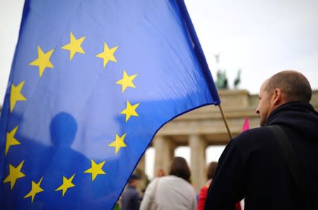 A demonstrator carries an EU flag during a rally under the slogan "Stop the Coup" to protest against attempts to force through a no-deal Brexit, in Berlin